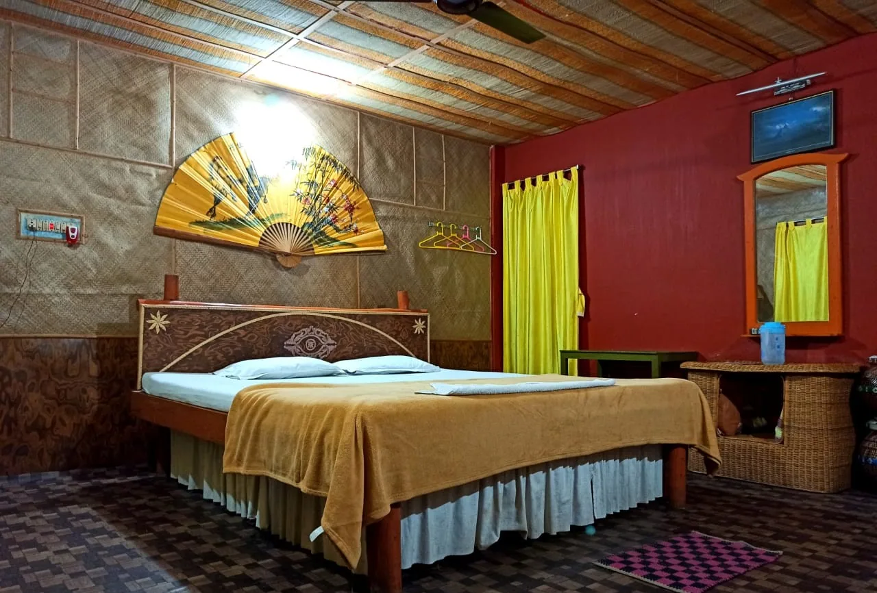 Standard non-AC room with bamboo ceiling and yellow curtains